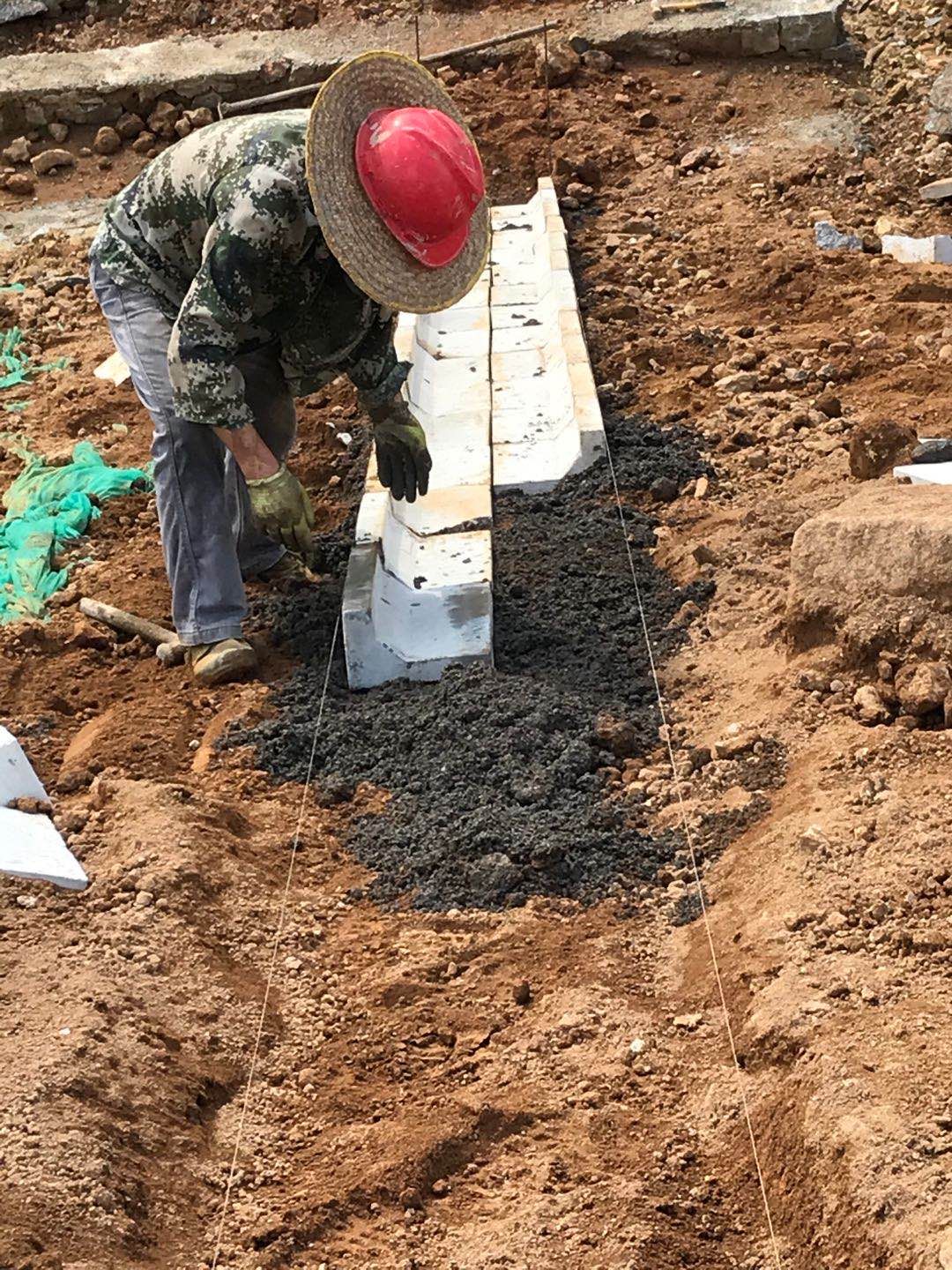工作人員正在使用人字型骨架預制塊搭建水泥骨架護坡